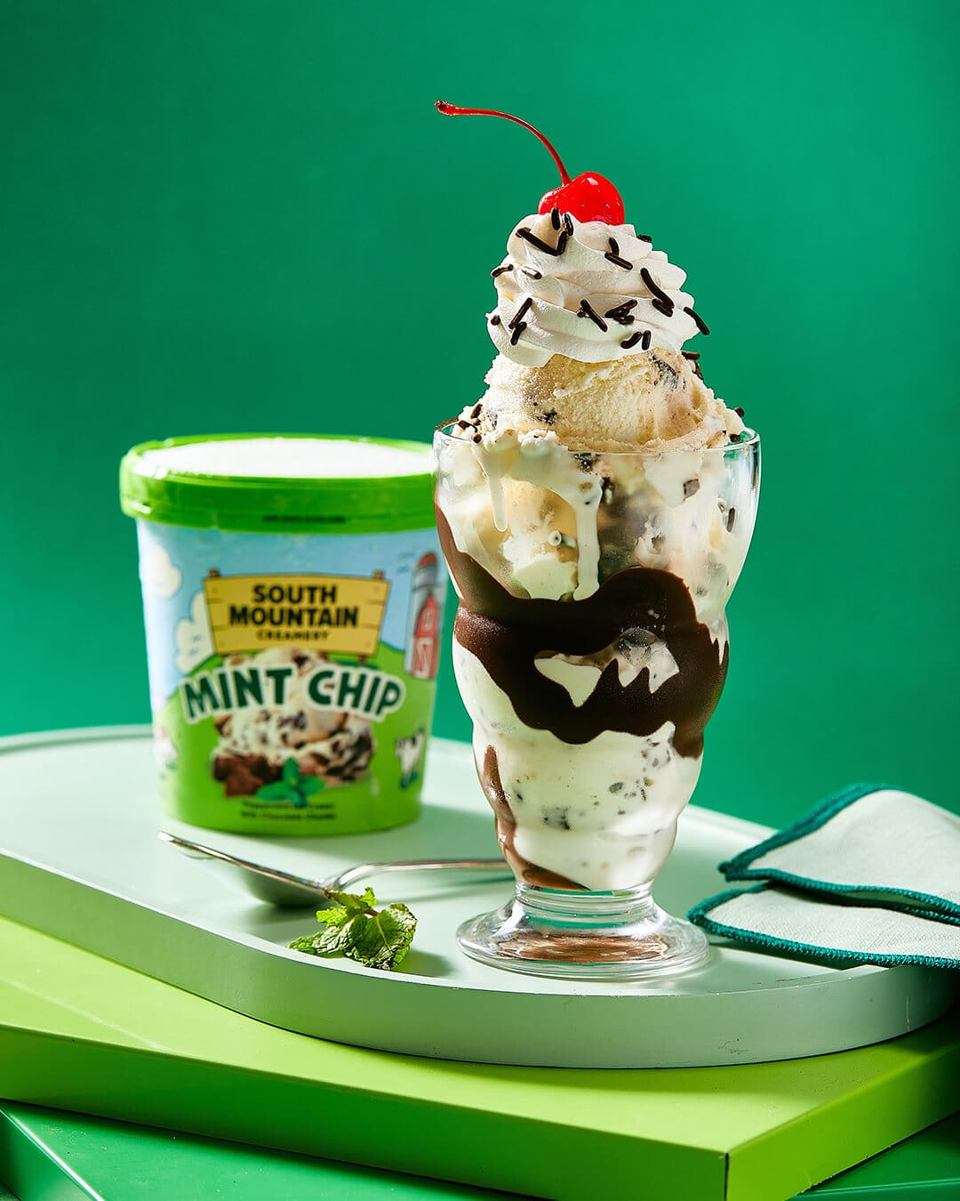 SMC Butter Pecan Ice Cream in waffle cup next to spoon on a dark background